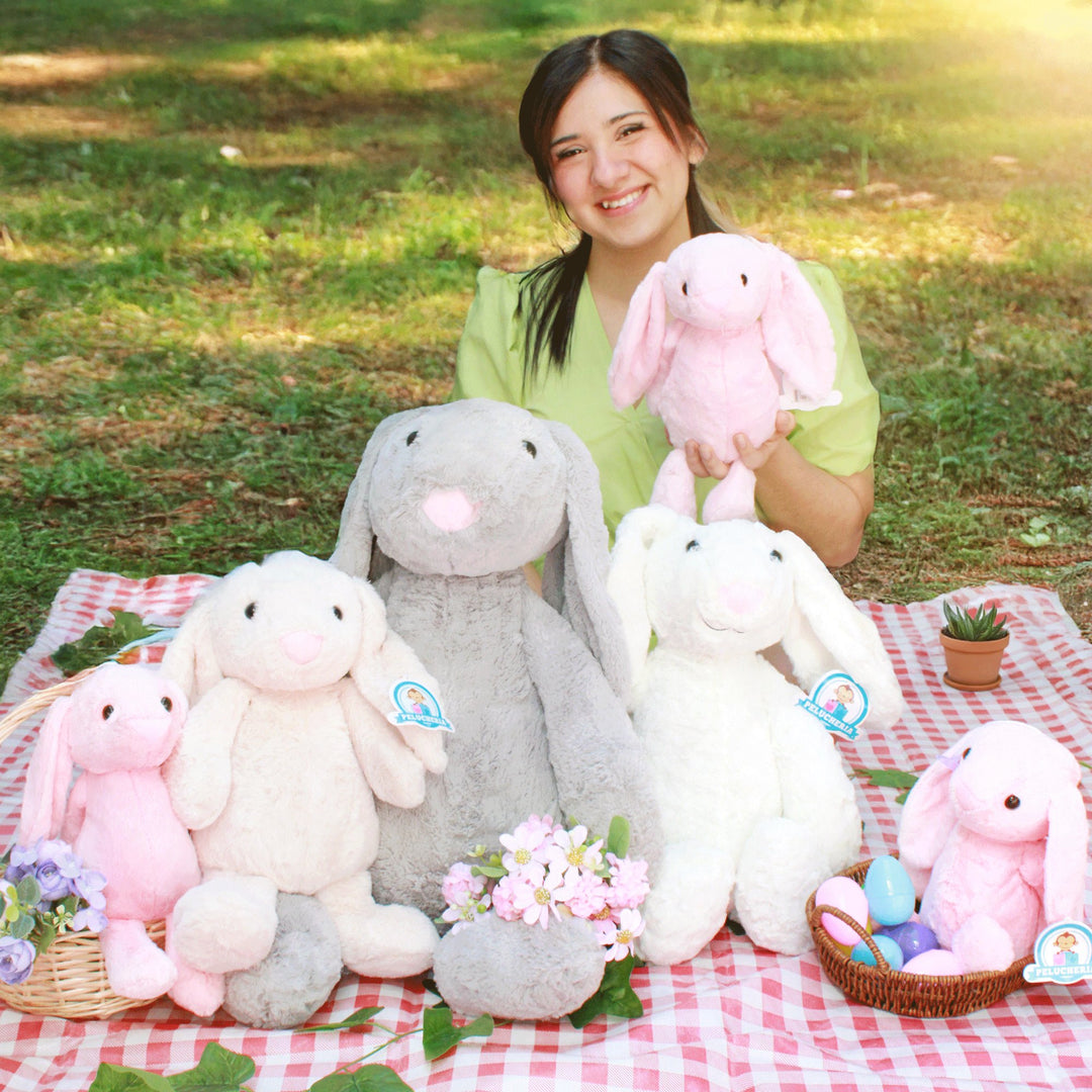 Peluches de conejitos de pascua de colores junto a huevos decorados
