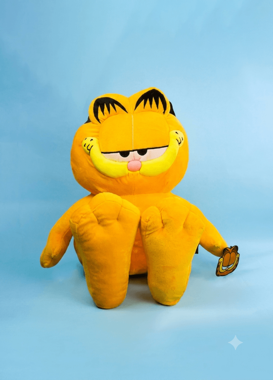 Peluche de Garfield clásico sentado mirando al frente sobre fondo gris