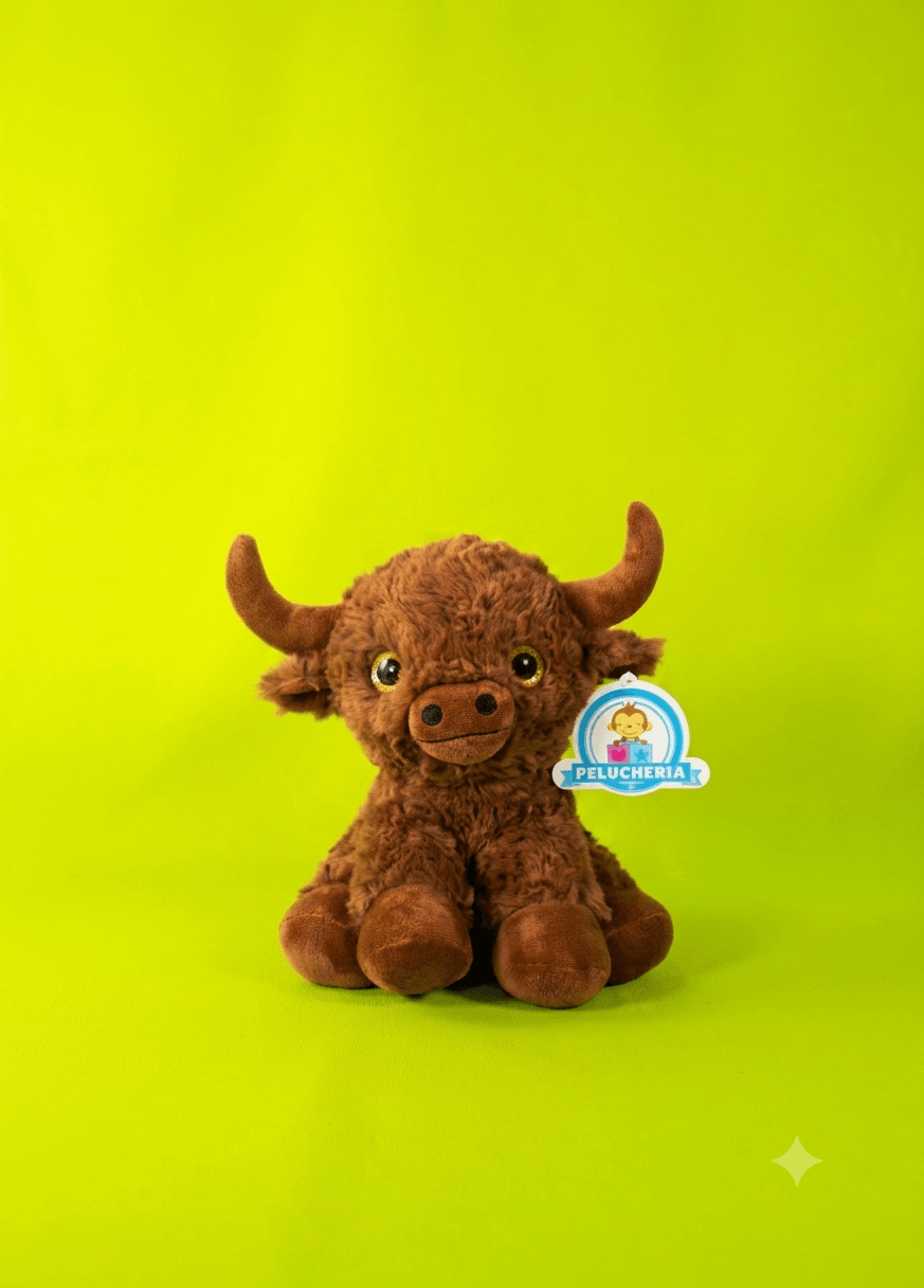 Peluche de toro color café con cuernos prominentes sobre fondo verde