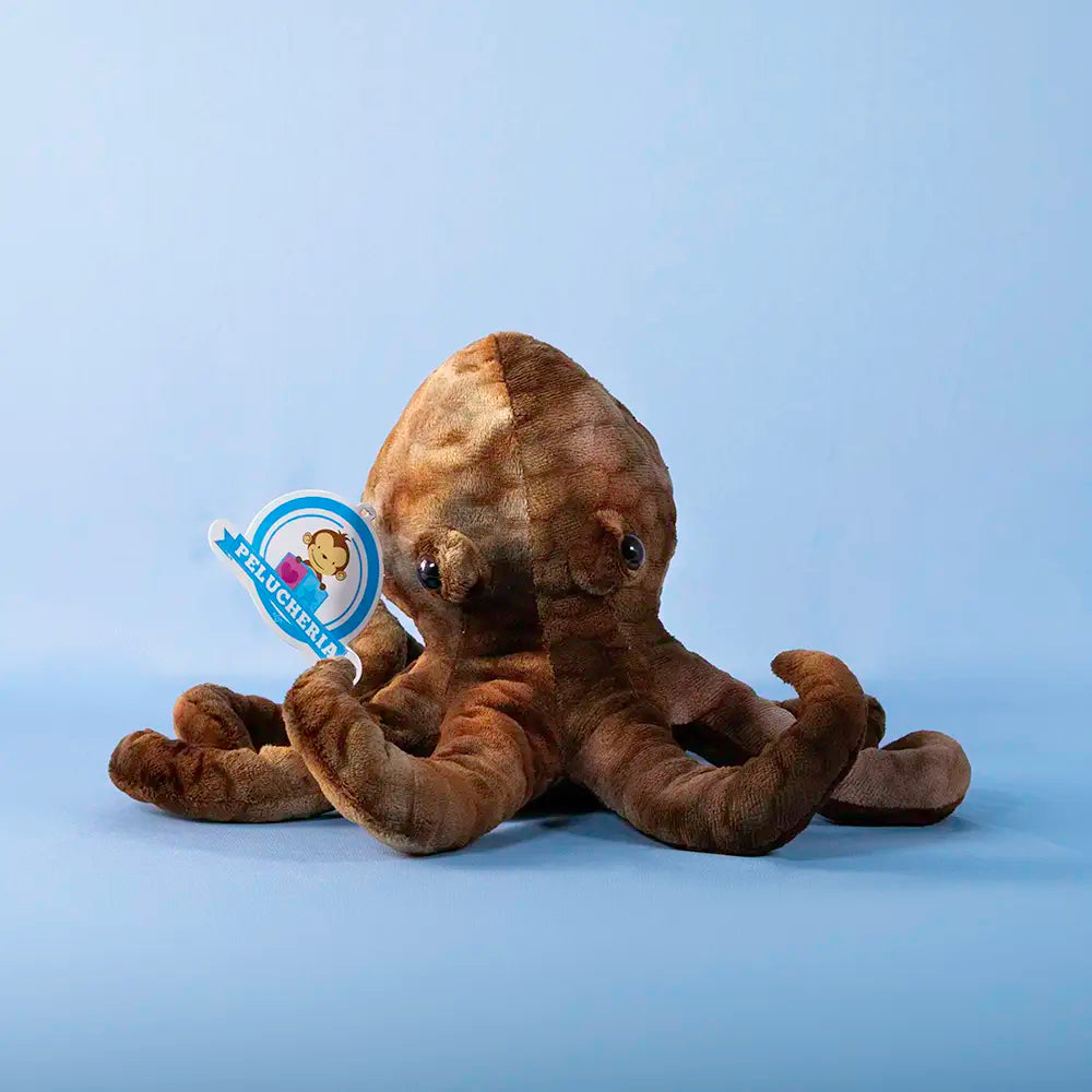 Peluche de tiburón gris sonriente mostrando los dientes sobre fondo azul