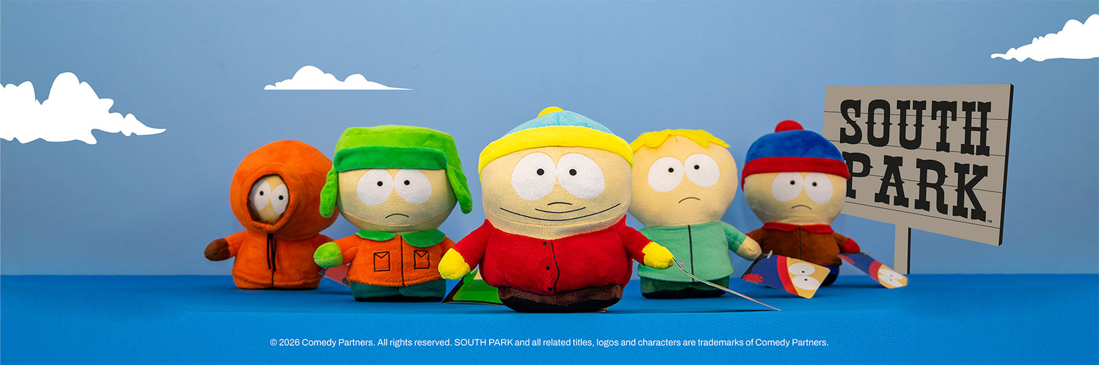 Colección de peluches de los personajes de South Park con letrero de la serie en Peluchería