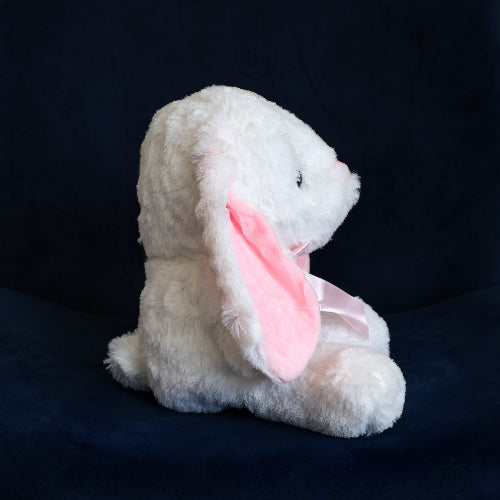 Conejo de peluche blanco con orejas largas, felpa suave y moño decorativo.