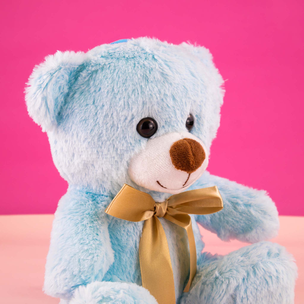 Oso de peluche color azul claro, de felpa suave, sentado y con moño. Peluches para baby showers , eventos y decoraciones
