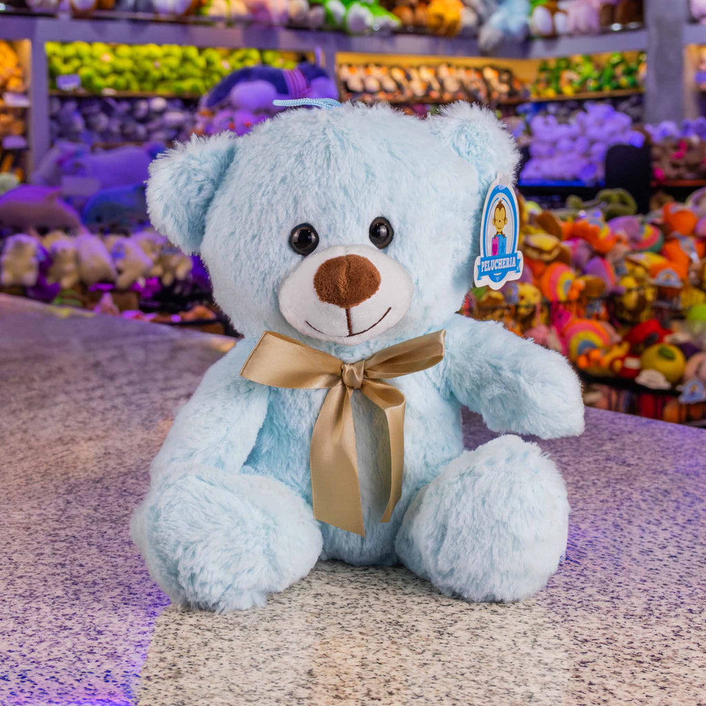 Oso de peluche color azul claro, de felpa suave, sentado y con moño. Peluches para baby showers , eventos y decoraciones