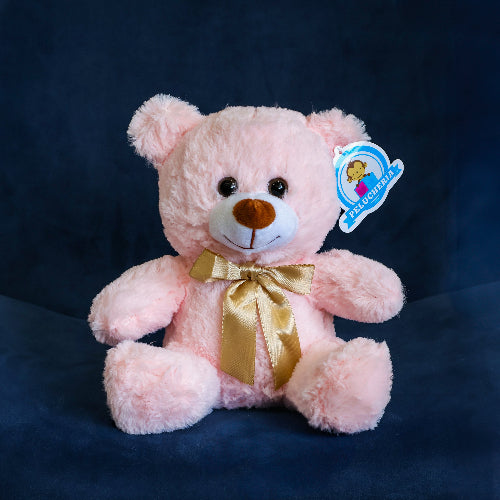 Oso de peluche color rosa con moño decorativo, ideal para regalo romántico o infantil.