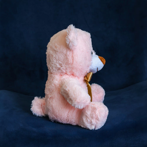 Oso de peluche color rosa con moño decorativo, ideal para regalo romántico o infantil.