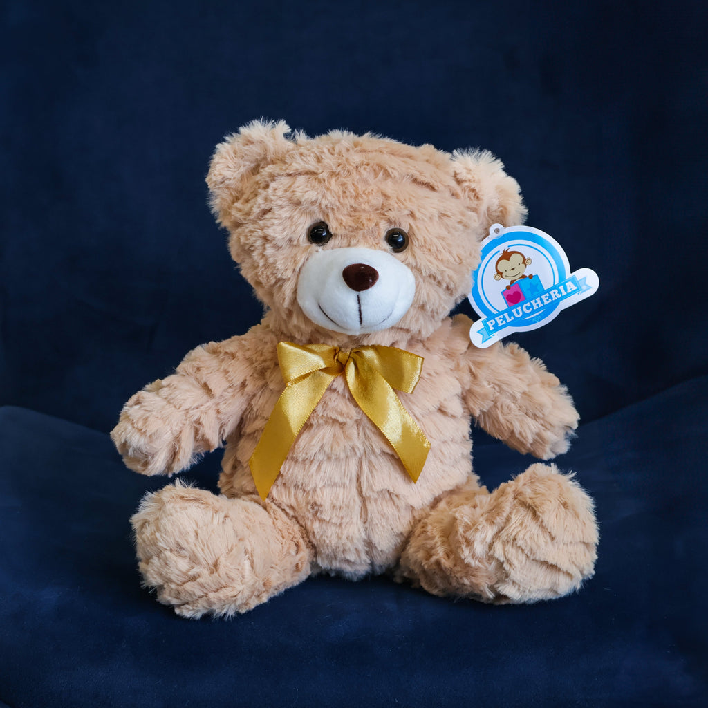 Oso de peluche color café con moño decorativo, suave y tierno, ideal para centros de mesa, regalos o recuerdos especiales.

