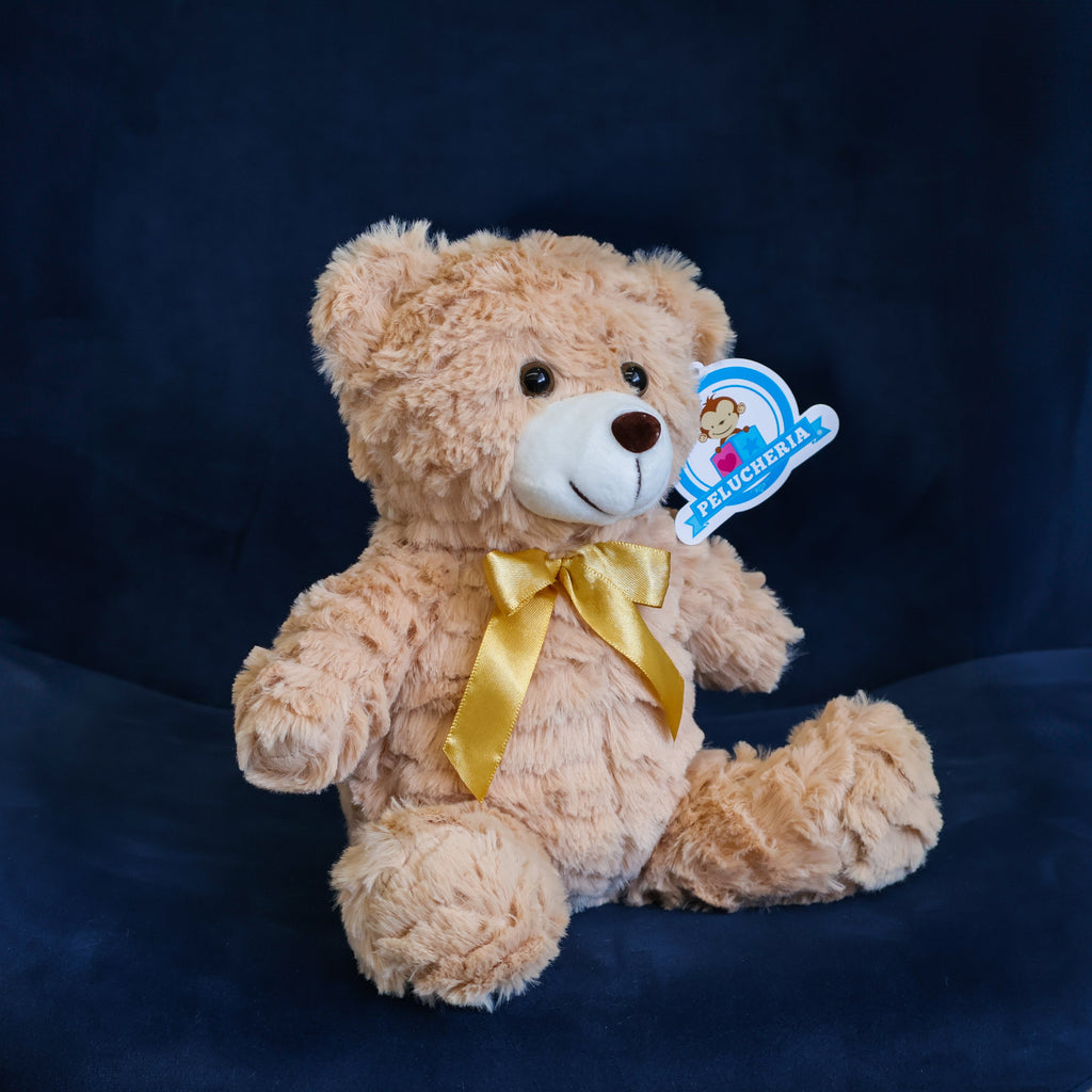 Oso de peluche color café con moño decorativo, suave y tierno, ideal para centros de mesa, regalos o recuerdos especiales.

