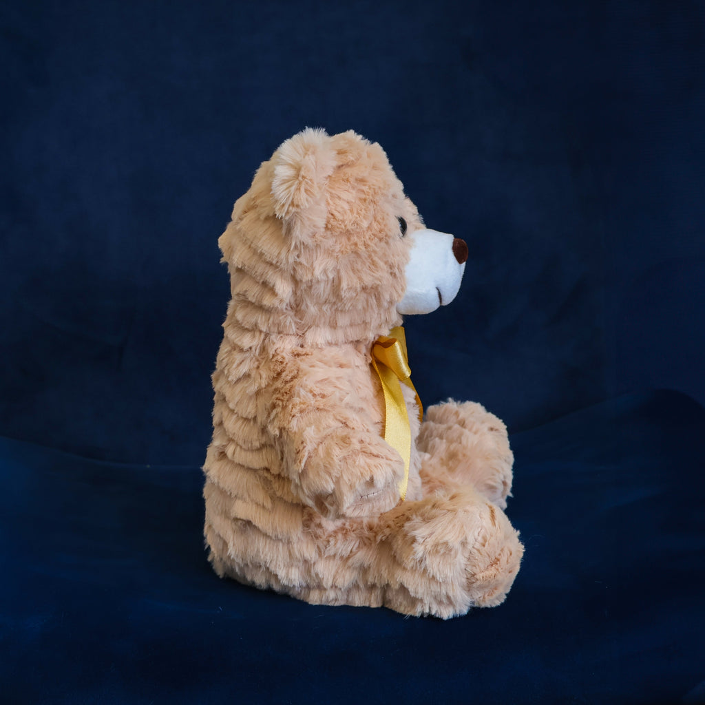 Oso de peluche color café con moño decorativo, suave y tierno, ideal para centros de mesa, regalos o recuerdos especiales.

