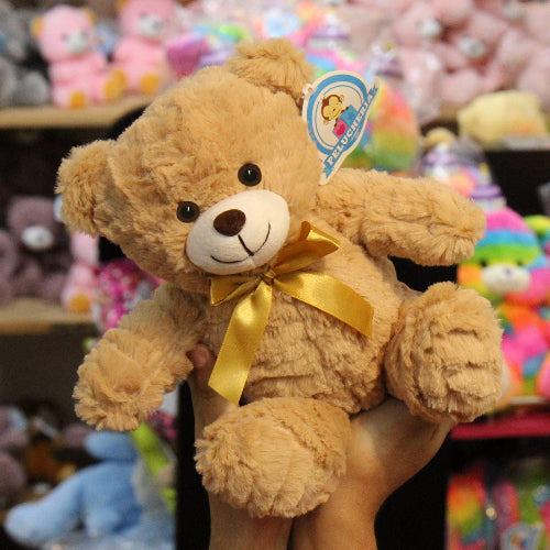 Oso de peluche color café con moño decorativo, suave y tierno, ideal para centros de mesa, regalos o recuerdos especiales.

