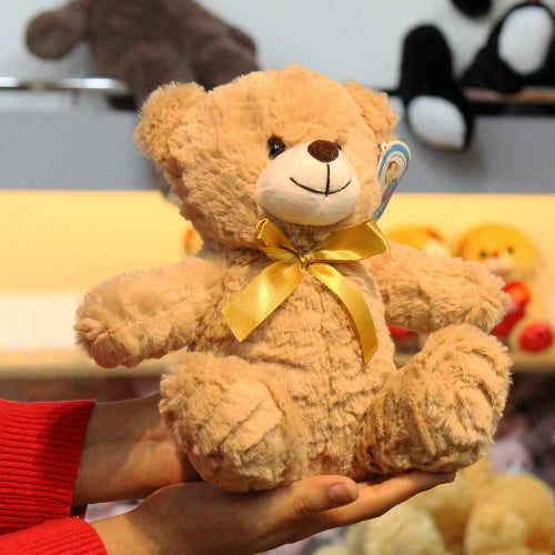 Oso de peluche color café con moño decorativo, suave y tierno, ideal para centros de mesa, regalos o recuerdos especiales.

