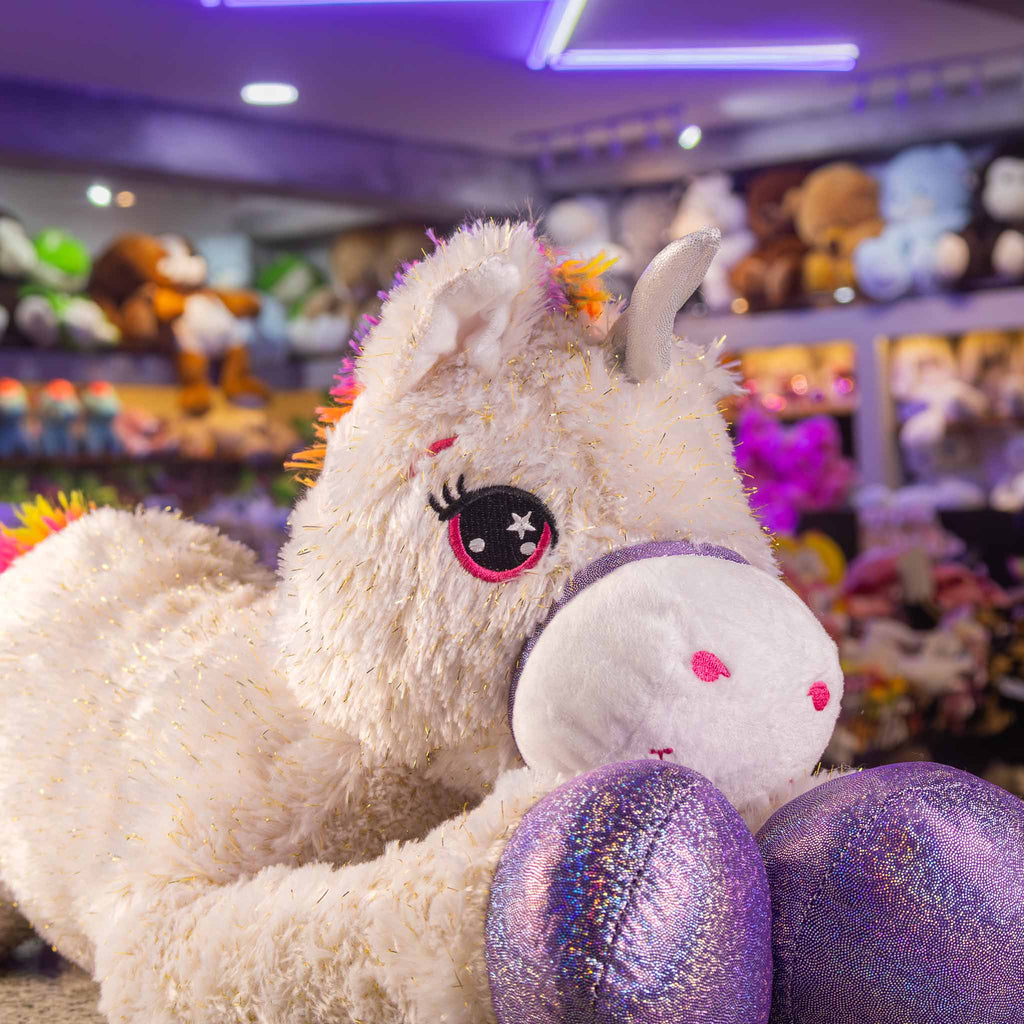 Unicornio de peluche gigante, color blanco con detalles brillantes. Ideal para tiendas de regalos y mayoristas