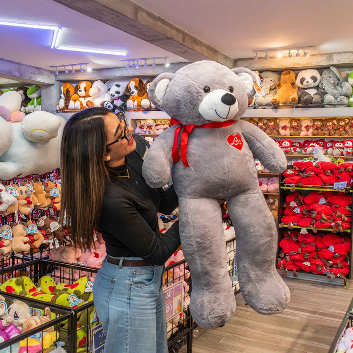 Oso de peluche meli super suave de color gris, ideal para regalos en cualrquier ocasión, en san valentin, regalar amor o decorar un espacio con un osito adorable.