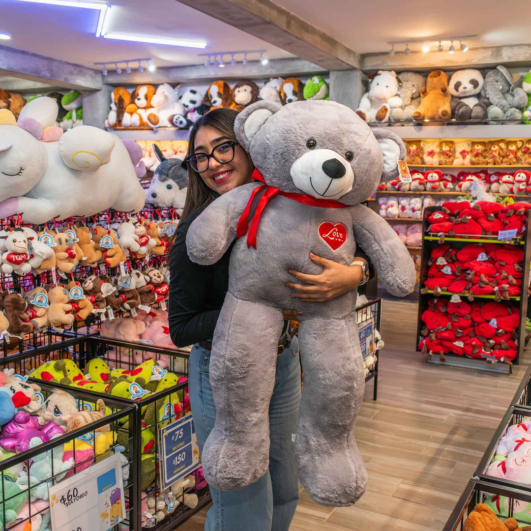 Oso de peluche meli super suave de color gris, ideal para regalos en cualrquier ocasión, en san valentin, regalar amor o decorar un espacio con un osito adorable.