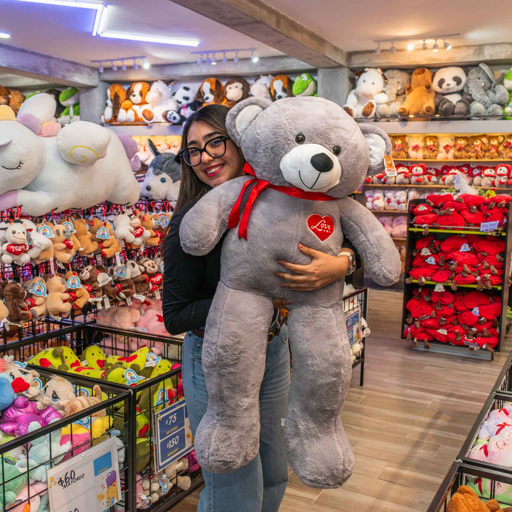 Oso de peluche meli super suave de color gris, ideal para regalos en cualrquier ocasión, en san valentin, regalar amor o decorar un espacio con un osito adorable.