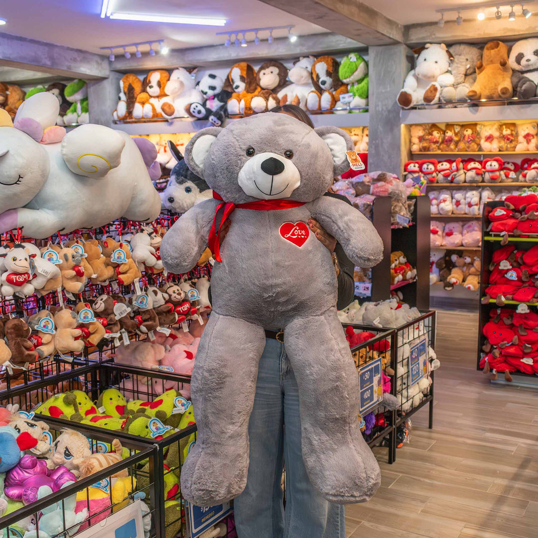 Oso de peluche meli super suave de color gris, ideal para regalos en cualrquier ocasión, en san valentin, regalar amor o decorar un espacio con un osito adorable.