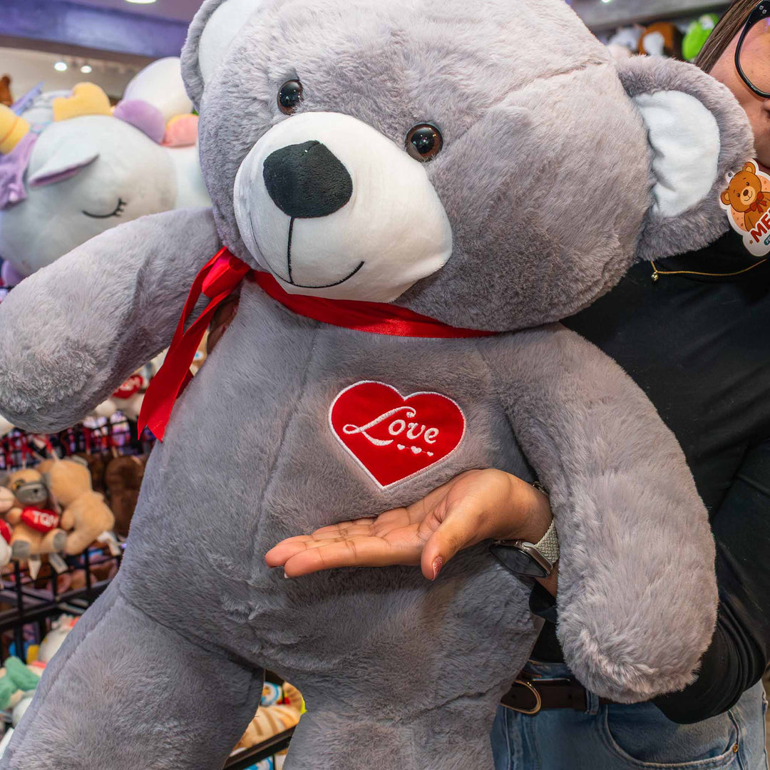 Oso de peluche meli super suave de color gris, ideal para regalos en cualrquier ocasión, en san valentin, regalar amor o decorar un espacio con un osito adorable.