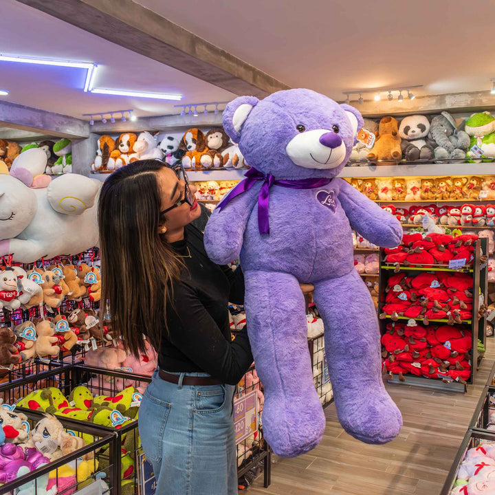 Oso de peluche meli super suave de color morado, ideal para regalos en cualrquier ocasión, en san valentin, regalar amor o decorar un espacio con un osito adorable.