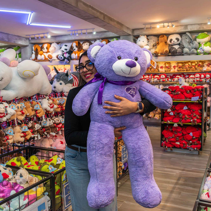 Oso de peluche meli super suave de color morado, ideal para regalos en cualrquier ocasión, en san valentin, regalar amor o decorar un espacio con un osito adorable.