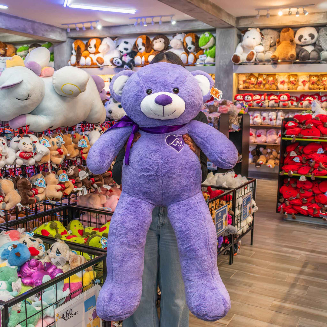 Oso de peluche meli super suave de color morado, ideal para regalos en cualrquier ocasión, en san valentin, regalar amor o decorar un espacio con un osito adorable.
